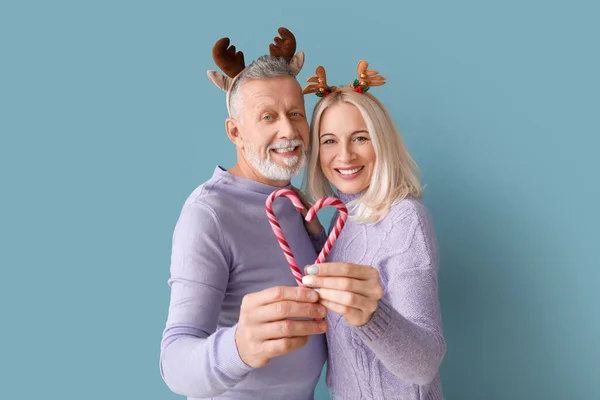 Happy Mature Couple Deer Horns Candy Canes Color Background — Stock Photo, Image
