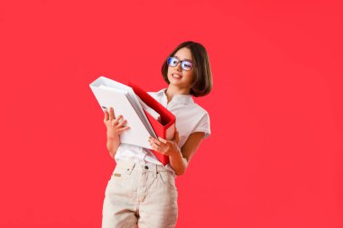 Renk arkaplanı klasörleri olan güzel genç bir kadın.