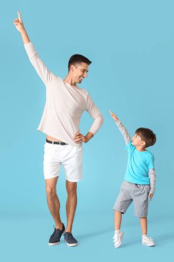 Dans eden adam ve küçük oğlu renkli arka planda