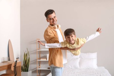 Adam ve küçük oğlu evde oynuyorlar.