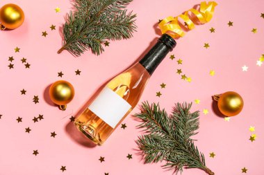 Şampanyalı kompozisyon ve pembe arka planda Noel dekoru.