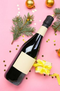 Şampanyalı kompozisyon ve pembe arka planda Noel dekoru.