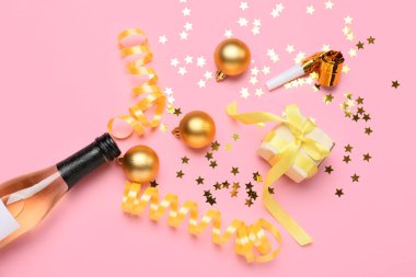 Şampanyalı kompozisyon ve pembe arka planda Noel dekoru.