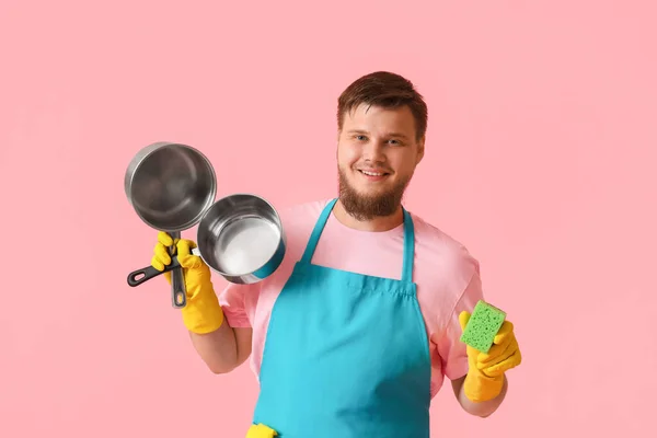 若いです男とともにスポンジと調理ポット上のピンクの背景 — ストック写真