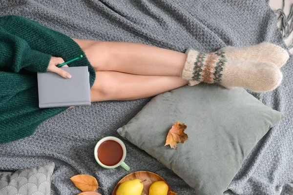 Женщина Блокнотом Чашкой Чая Едой Осенними Листьями Серой Клетке — стоковое фото