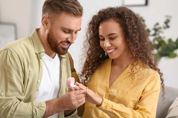 若い男を置く婚約指輪彼のガールフレンドの指に自宅で — ストック写真