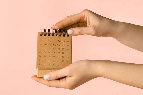 Женщина Держит Календарь Ремесел Розовом Фоне — стоковое фото