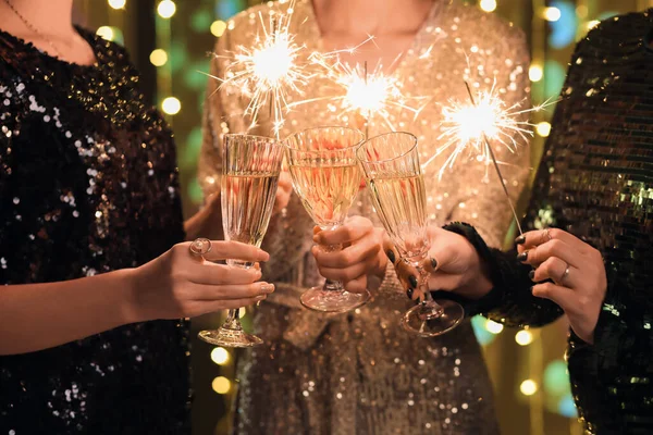 Junge Frauen Eleganten Kleidern Mit Champagnergläsern Und Weihnachtsbeleuchtung Nahaufnahme — Stockfoto