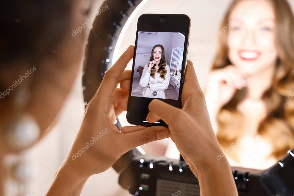 Woman taking photo of beautiful model in makeup room