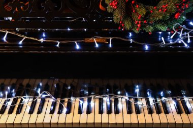 Parlak ışıkları ve çelengi olan piyano, yakın plan.