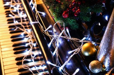 Siyah piyanoda Noel dekoru ile parlayan ışıklar, yakın plan