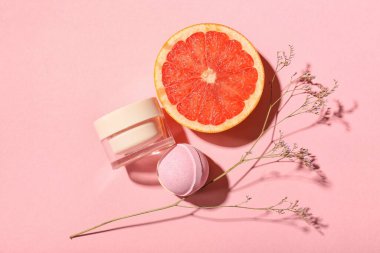 Banyo bombası, kozmetik ürün kavanozu, greyfurt ve arkaplanda kurutulmuş çiçek.