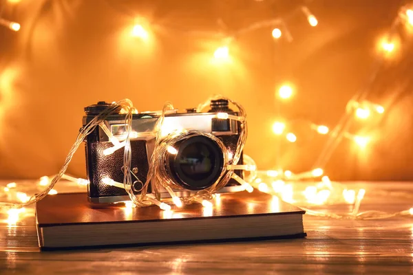 Рождественские Огни Фотоаппарат Книга Столе Белой Стены — стоковое фото