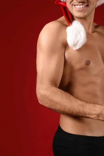 Sexy Junger Mann Mit Weihnachtsmütze Und Unterwäsche Auf Farbigem Hintergrund — Stockfoto