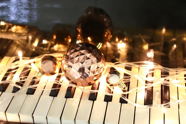 Christmas Balls Glowing Lights Piano Keys Closeup — Stok Foto