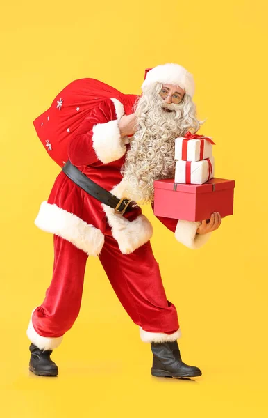 Kerstman Met Tas Cadeautjes Gele Achtergrond — Stockfoto