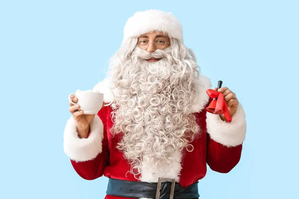 Święty Mikołaj Dzwonkiem Świątecznym Filiżanką Kakao Niebieskim Tle — Zdjęcie stockowe