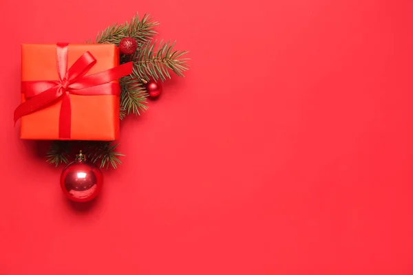 赤い背景に美しいクリスマスの贈り物 モミの枝や装飾と構成 — ストック写真