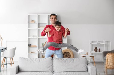 Adam ve küçük oğlu evde oynuyorlar.