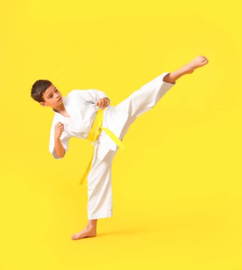 Küçük çocuk renkli arka planda karate yapıyor.
