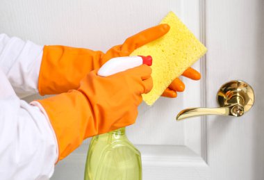 Beyaz kapının yanındaki süngere deterjan sıkan kadın.