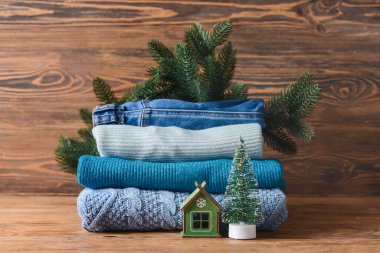 Örgü süveter yığını ve Noel süslemesi ahşap masada.