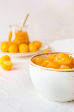 Hafif arka planda bir kase lezzetli kumkuat reçeli, yakın plan.