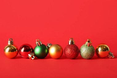 Kırmızı arka planda birçok farklı Noel baloları