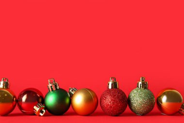 Kırmızı arka planda farklı Noel topları