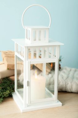 Renk duvarının yanındaki masada yanan mum olan güzel bir fener.