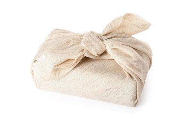 Beyaz arkaplanda kumaşa sarılı bir hediye kutusu