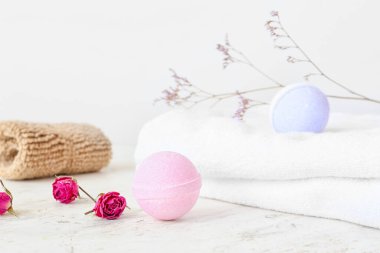 Banyo bombaları, havlular ve arka planda gül çiçekleri