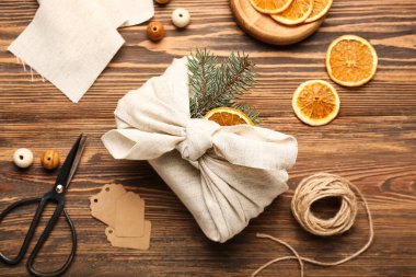 Ahşap arka planda kumaş ve dekora sarılı Noel hediyeli kompozisyon