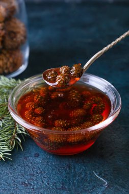 Koyu arkaplanda bir kase lezzetli kozalak reçeli, yakın plan.