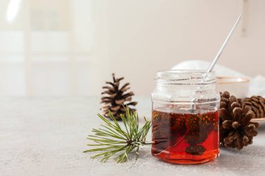 Hafif arkaplanda bir kavanoz çam kozalağı reçeli