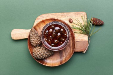 Yeşil arka planda bir kavanoz lezzetli çam kozalağı reçeli.