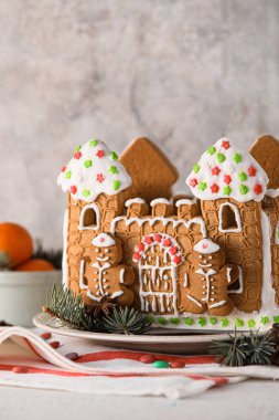 Masanın üzerinde güzel zencefilli kurabiye evi olan bir tabak.