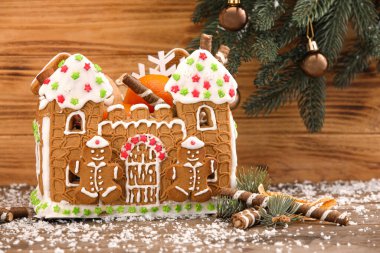 Güzel zencefilli kurabiye evi ve ahşap arka planda Noel dekoru.