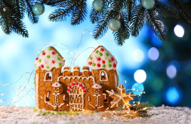 Noel dekoru ve zencefilli kurabiye evi bulanık arka planda.