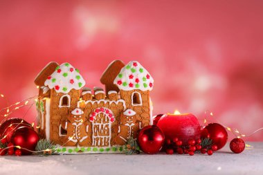 Güzel zencefilli kurabiye evi ve Noel dekoru bulanık arka planda.
