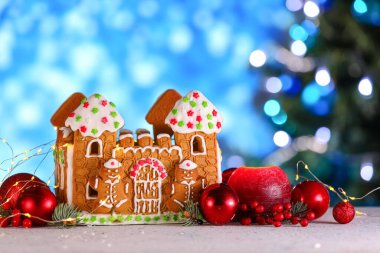 Güzel zencefilli kurabiye evi ve Noel dekoru bulanık arka planda.