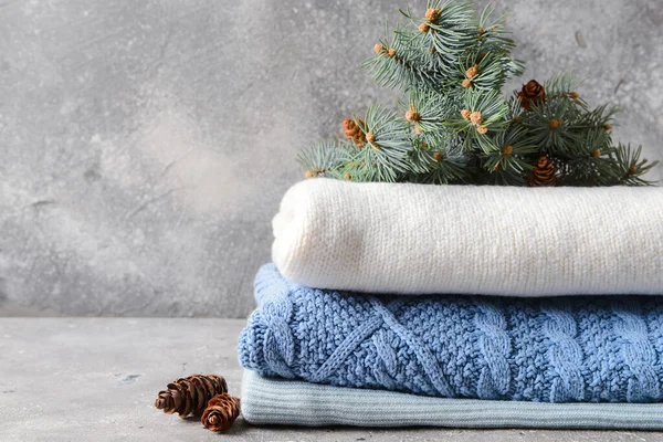 Süveter yığını ve grunge arkaplanda köknar ağacı dalı