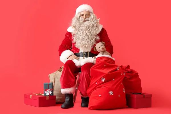 Kerstman Met Tas Cadeautjes Rode Achtergrond — Stockfoto