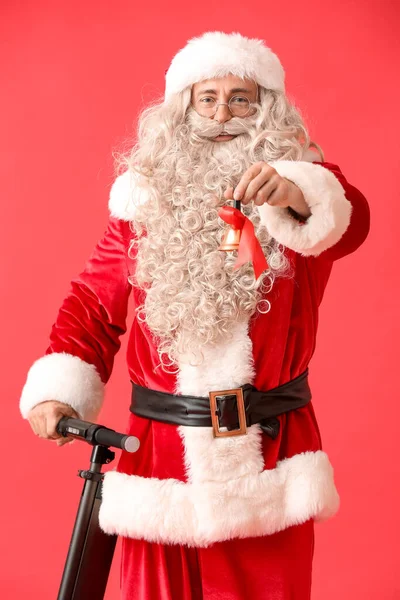 Weihnachtsmann Mit Weihnachtsglocke Und Elektrofahrrad Auf Rotem Hintergrund — Stockfoto