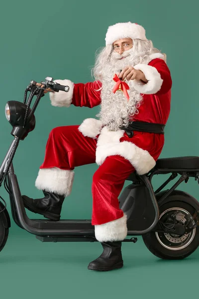 Santa Claus Dzwonkiem Świątecznym Rower Elektryczny Zielonym Tle — Zdjęcie stockowe