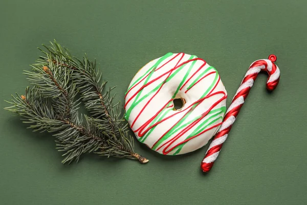 Leckerer Weihnachts Donut Mit Tannenzweig Und Zuckerrohr Auf Grünem Hintergrund — Stockfoto