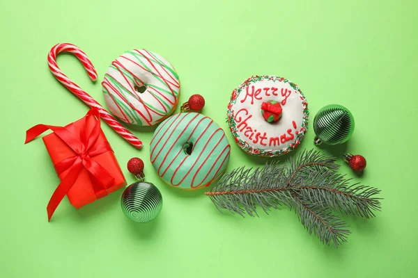 Leckere Weihnachtskrapfen Mit Tannenzweig Kugeln Und Zuckerrohr Auf Grünem Hintergrund — Stockfoto