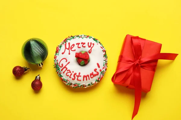 Leckere Weihnachts Donut Mit Kugeln Und Geschenk Auf Gelbem Hintergrund — Stockfoto