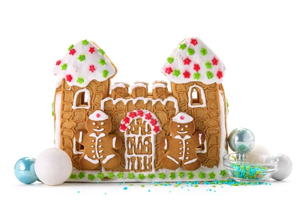 Güzel zencefilli kurabiye evi ve beyaz arka planda izole edilmiş Noel dekoru.