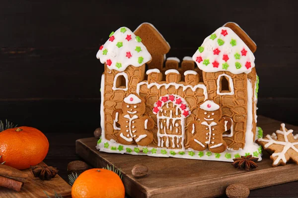 Güzel zencefilli ekmek evi ve siyah ahşap arka planda mandalinalar.